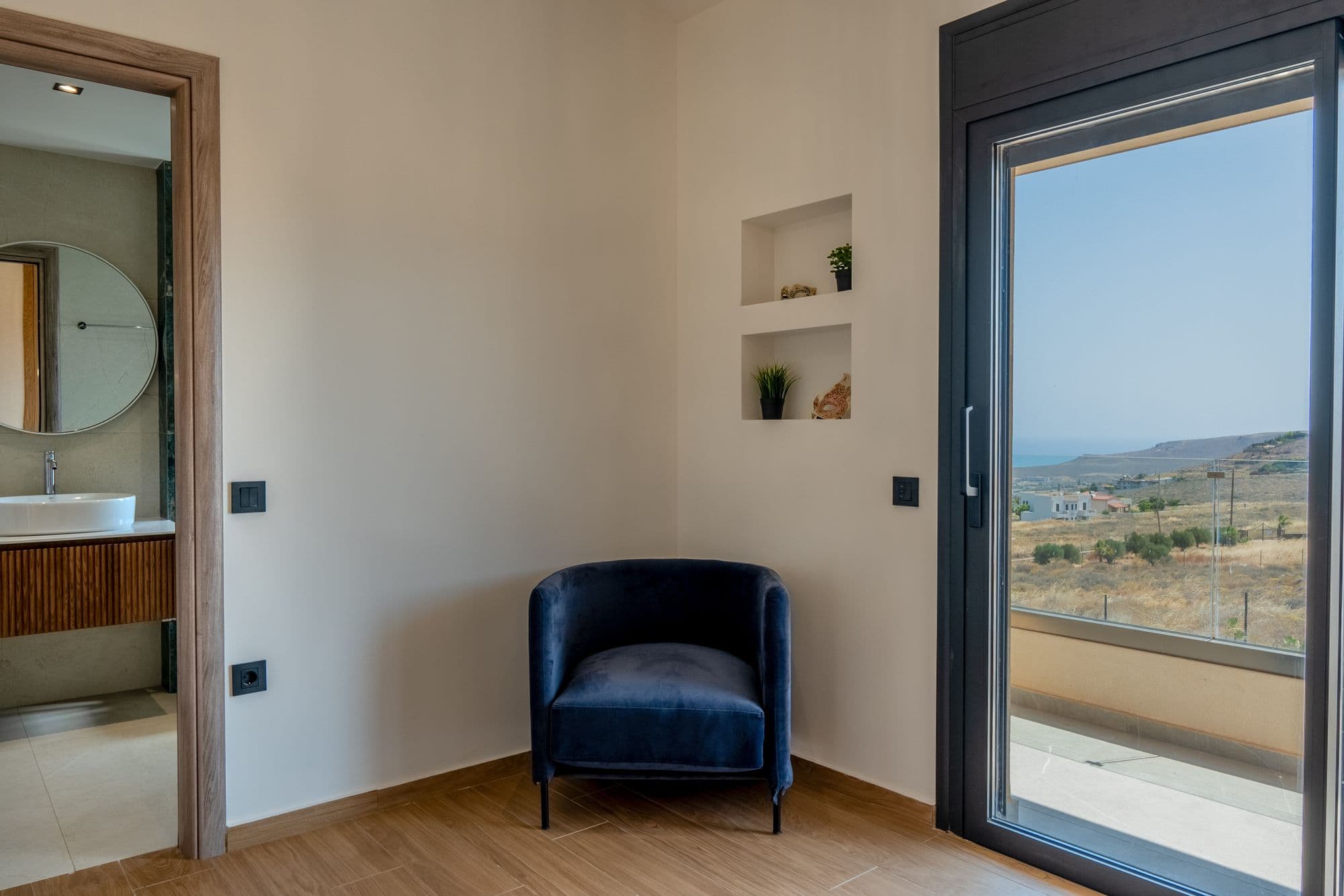 Lounge seating area with panoramic doors framing valley and coastal landscape views